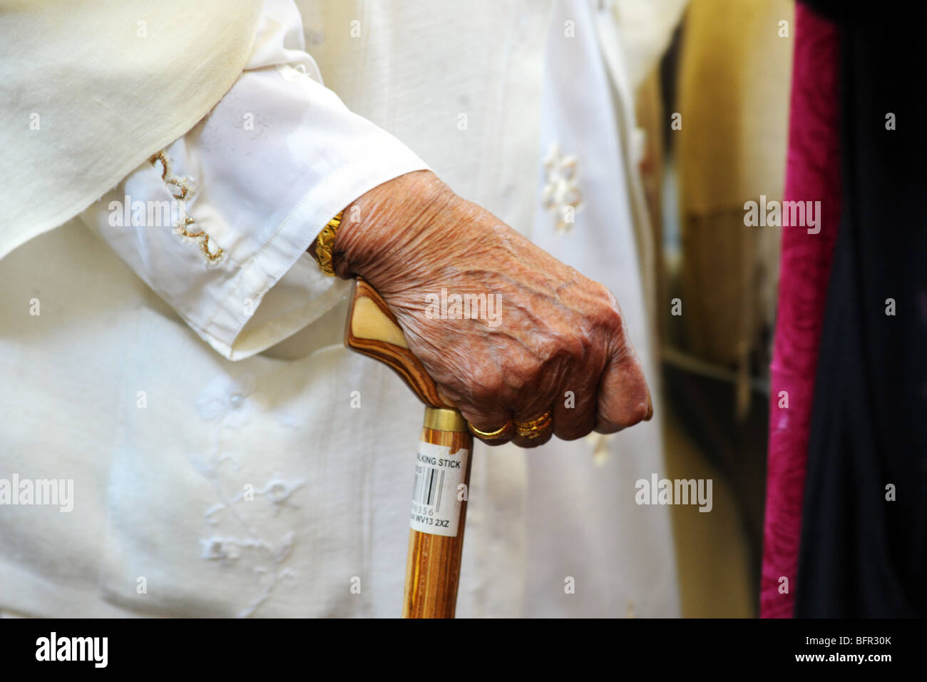 Elderly woman's hand using walking stick Stock Photo