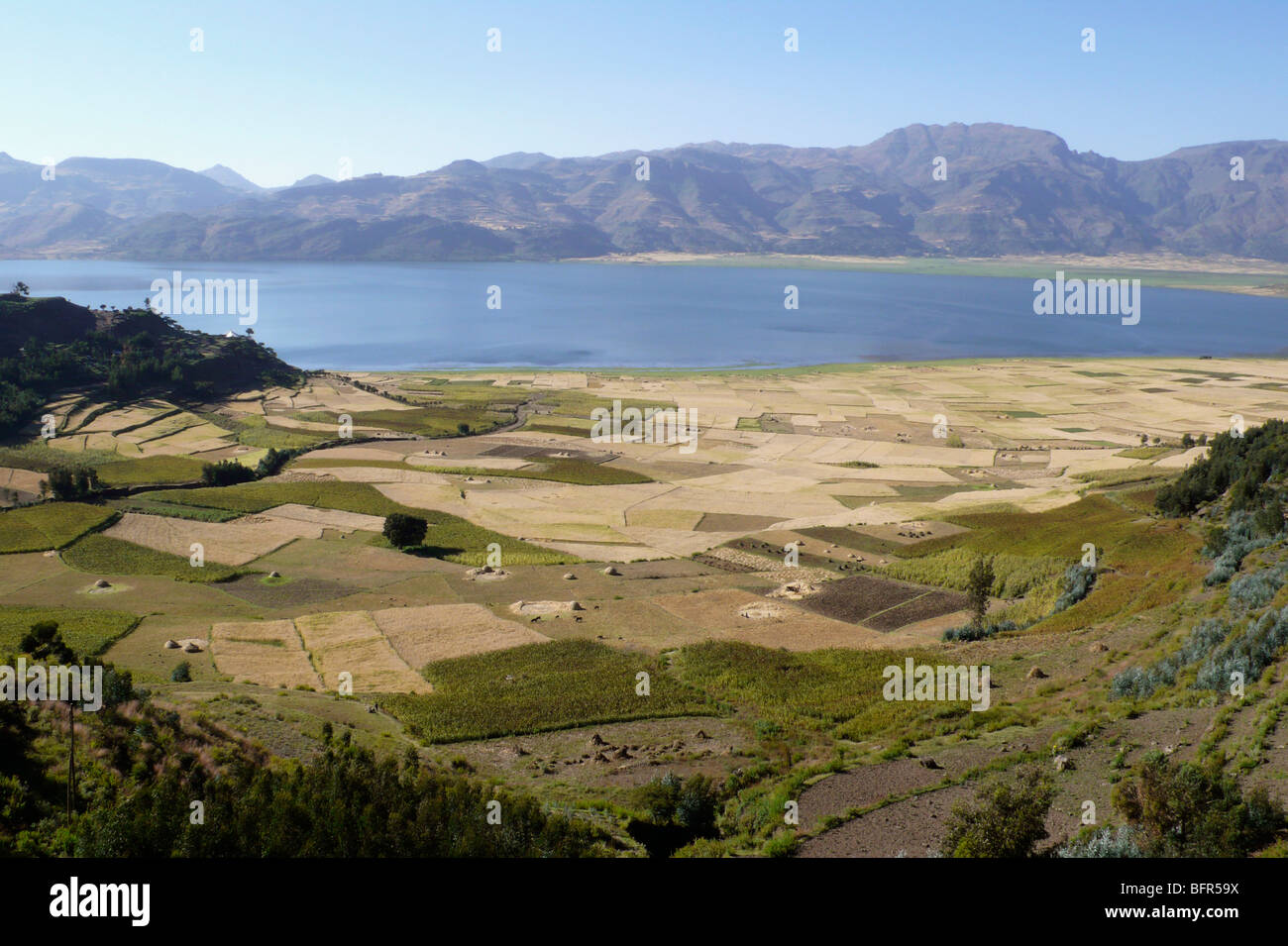 View over agricultural land from highland plateau towards a valley lake surrounded by agriculture Stock Photo