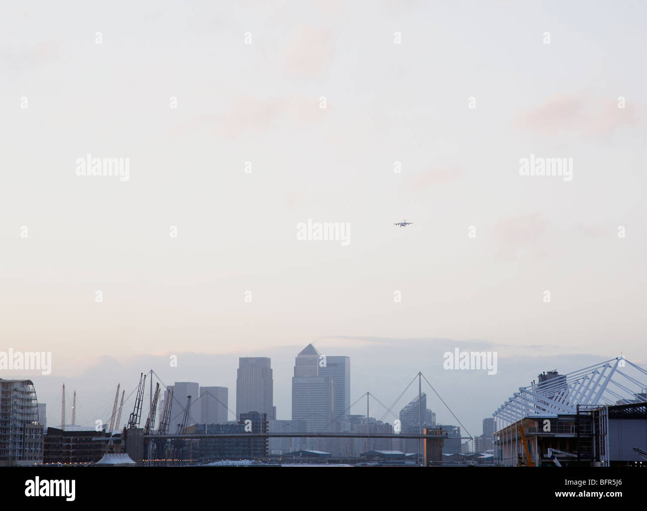 plane on its approach into London City Airport with view of Canary wharf in the background Stock Photo