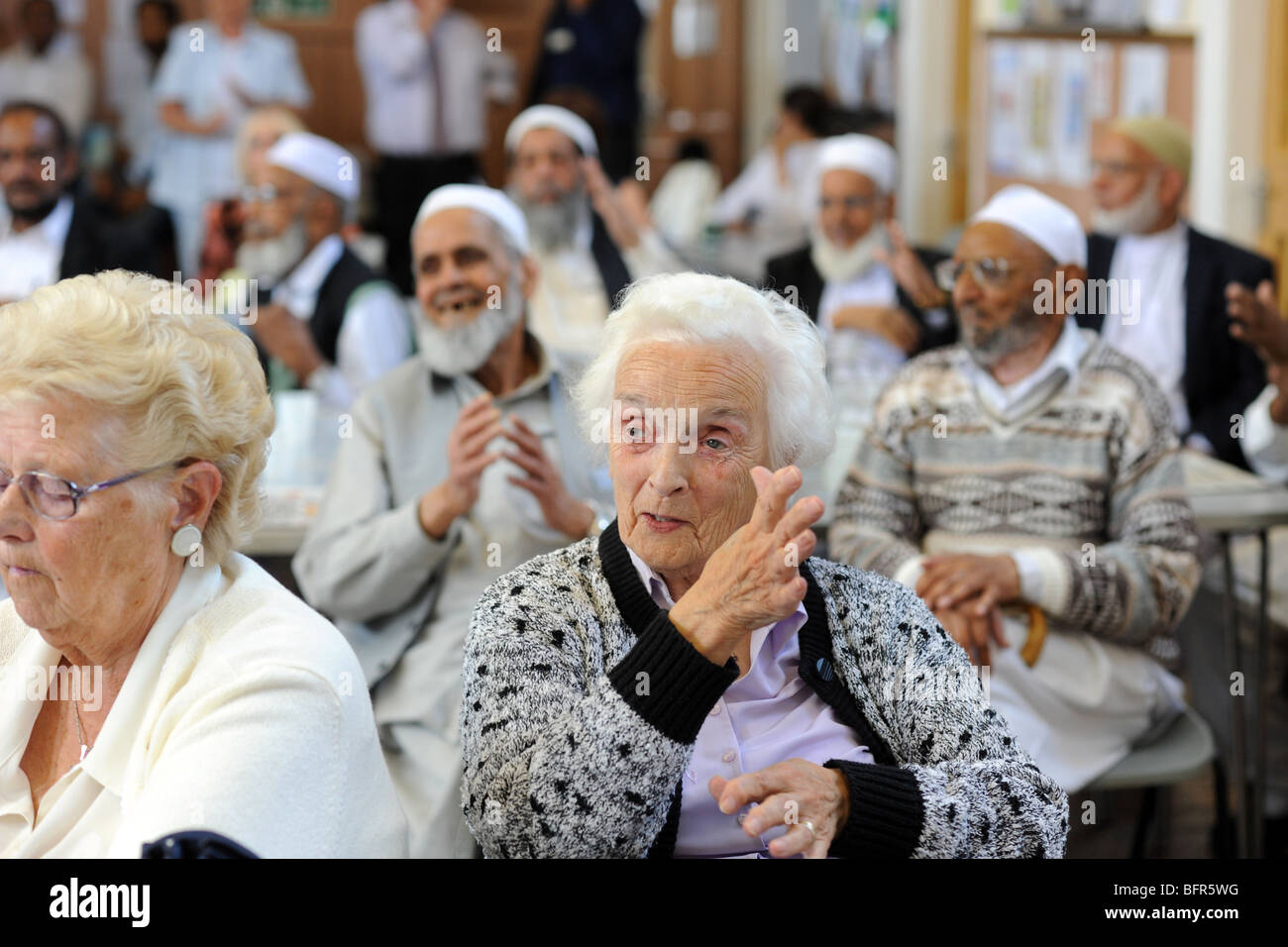 A mixed multi-cultural group of elderly people exercise in their ...