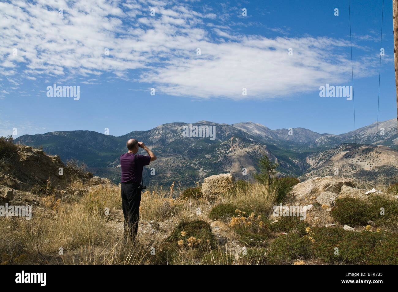 dh Males area IERAPETRA GREECE CRETE Birdwatcher looking for Cretan Dikti mountain birdlife with binoculars Stock Photo
