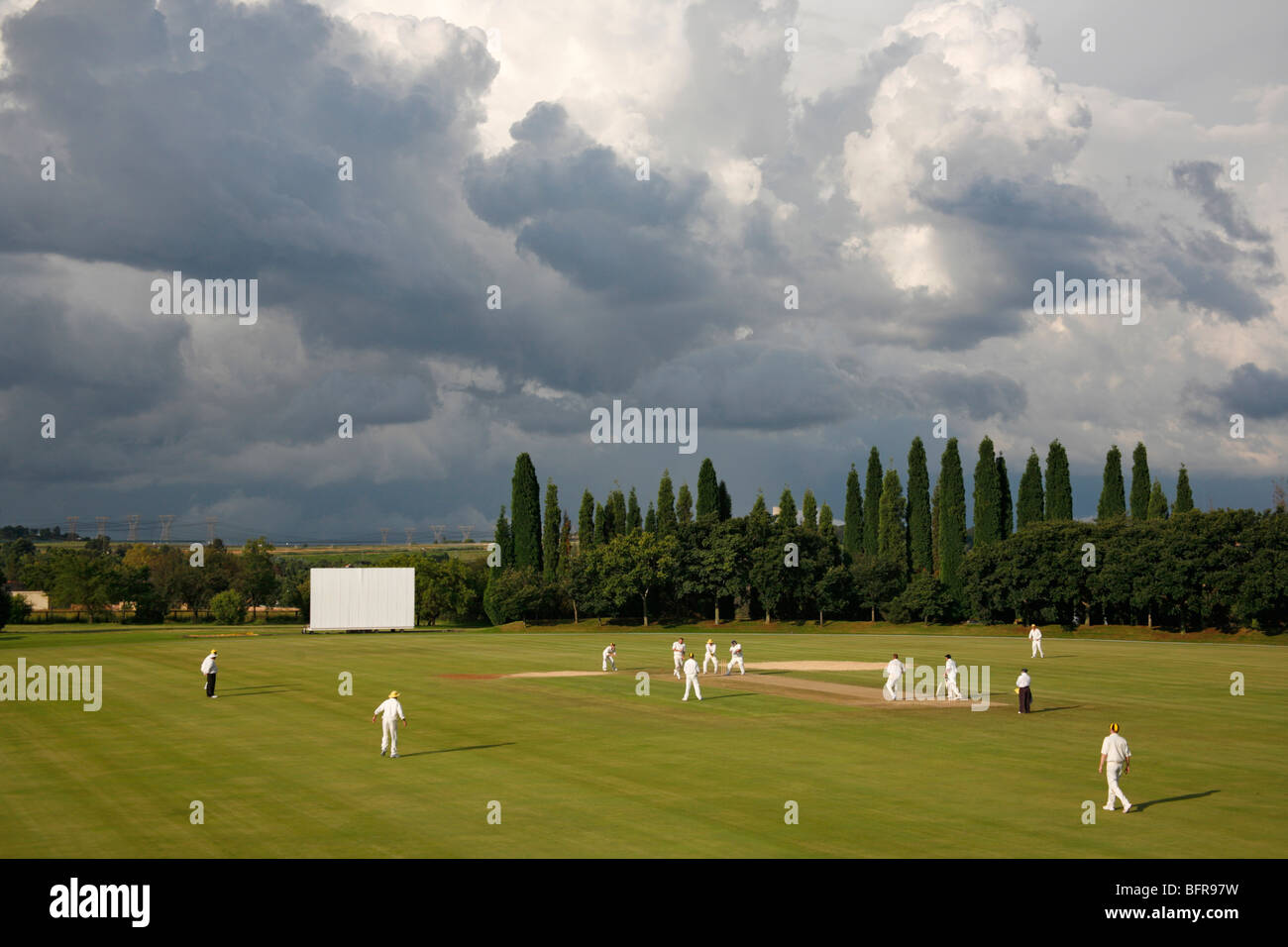 A game of cricket being played at Raindjiesfontein with an approaching summer storm Stock Photo