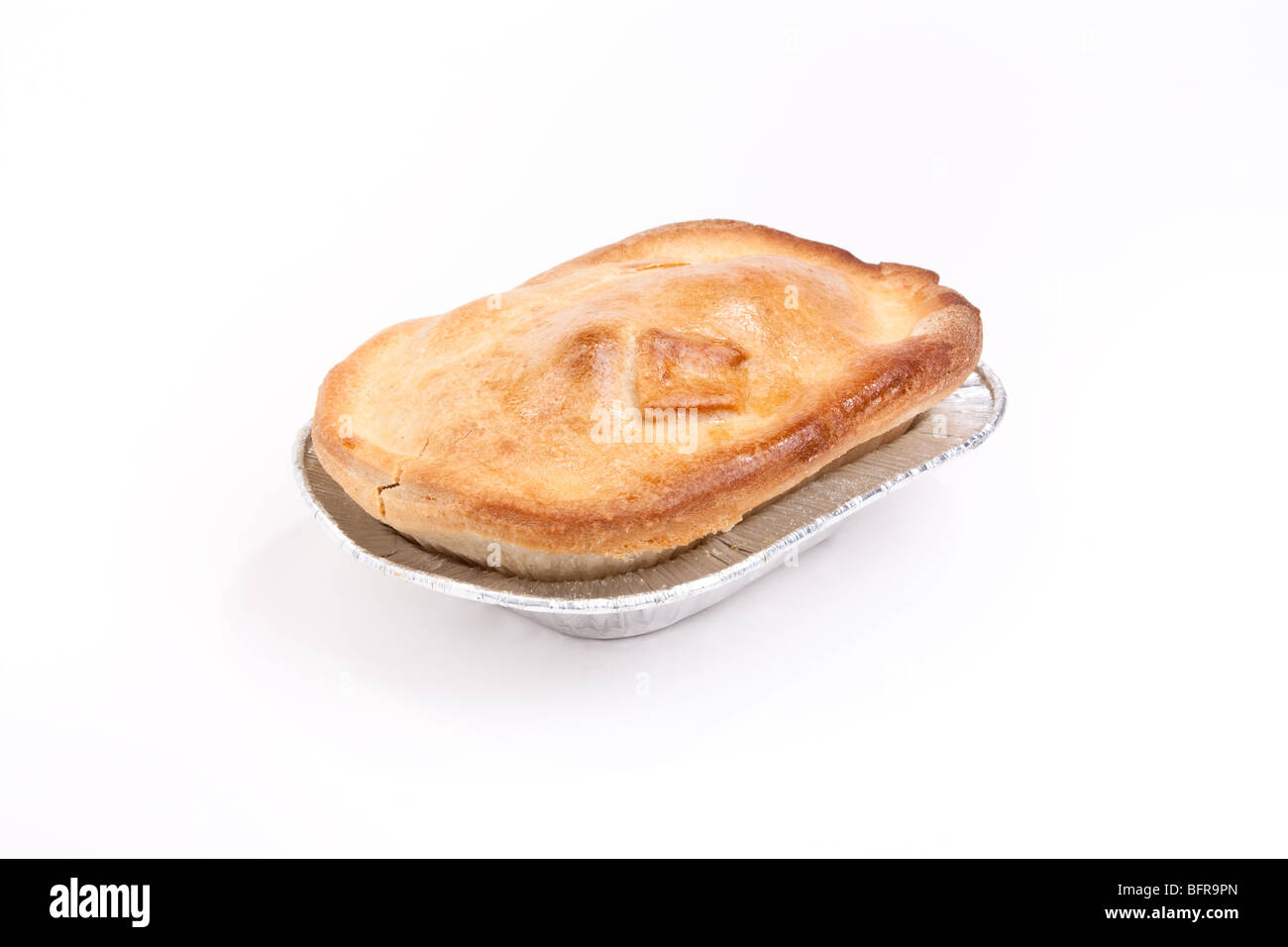 Individual short crust pastry steak pie in silver foil tray isolated against white background Stock Photo