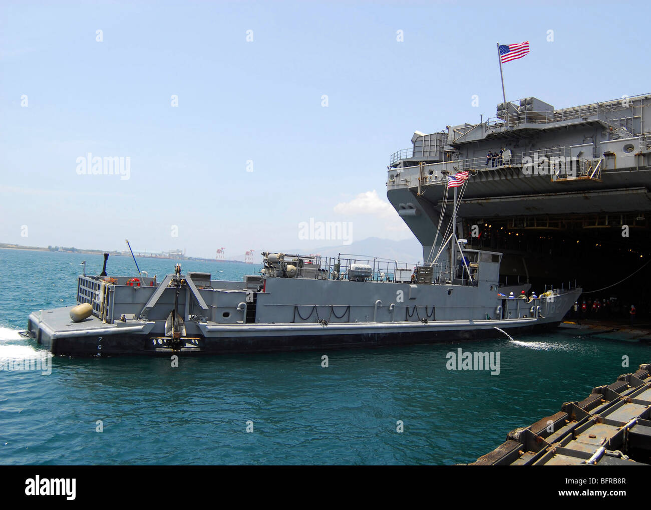 Landing Craft Utility moving into position near amphibious assault ship USS Essex in Subic Bay, Philippines. Stock Photo