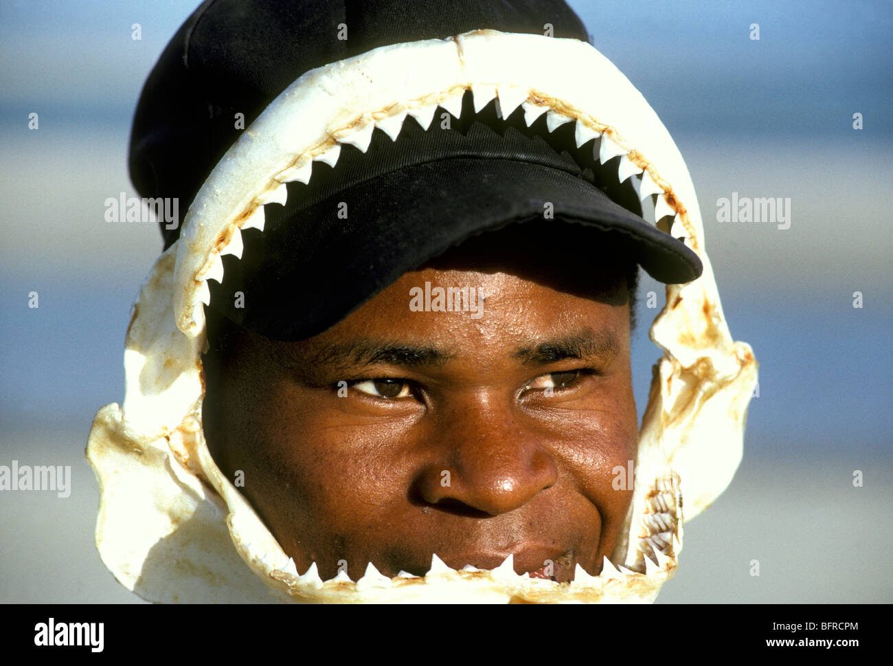 Anwar Alexander with sharks jaw draped over his face for sale to tourists Stock Photo