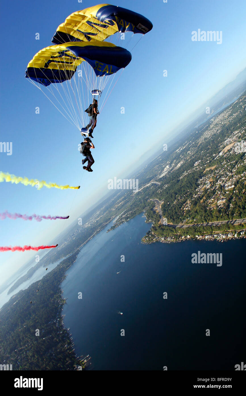 Members of the U.S. Navy Parachute Team, the Leap Frogs, perform a bi-plane with their parachutes above Seattle. Stock Photo