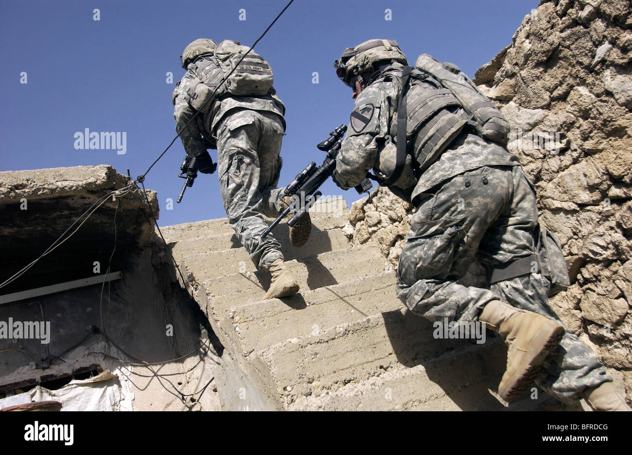 Soldiers running up staircase of a building during a mission in Mosul, Iraq. Stock Photo