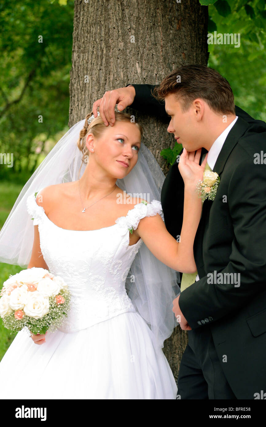 Three quarter body portrait of happy young couple looking lovingly at each other in forest. Stock Photo