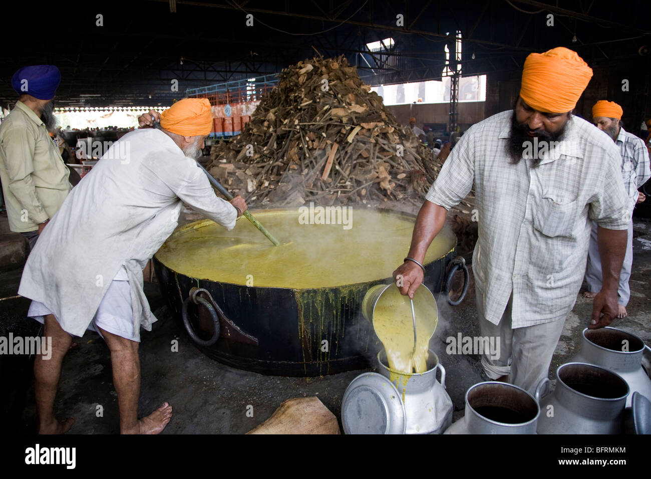 Sikh men cooking dhal (curried lentils) on a huge pot. The Golden