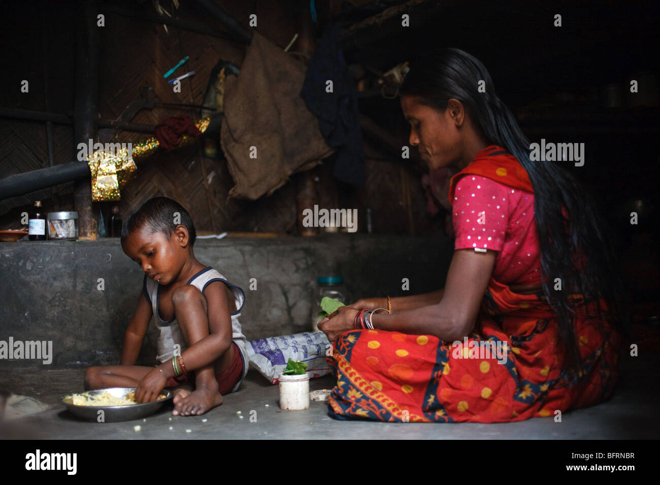 A boy has his meal in his hut in one of the slums in Kolkata, India Stock Photo