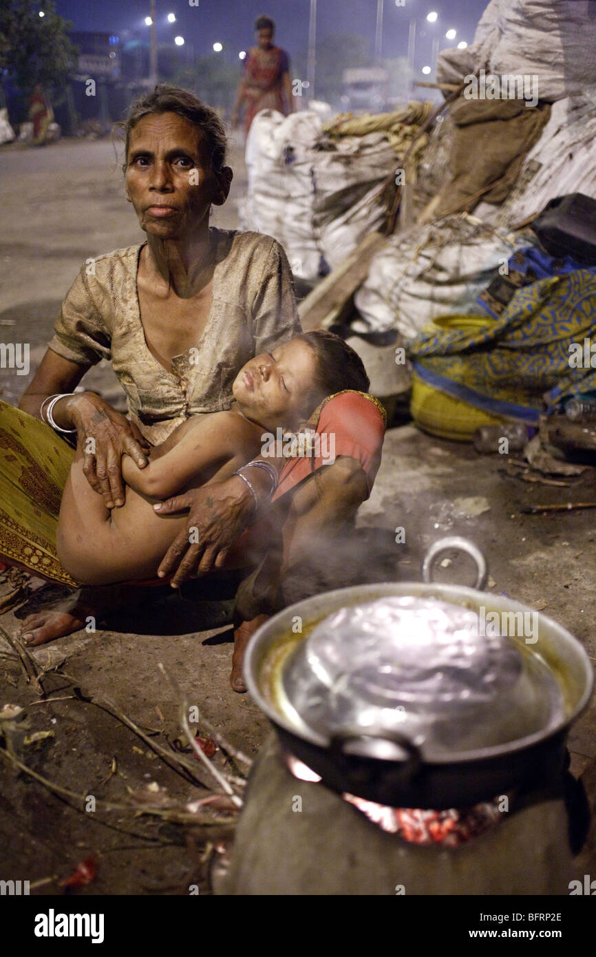 A woman with a sleeping child in one of the slums in Kolkata, India Stock Photo