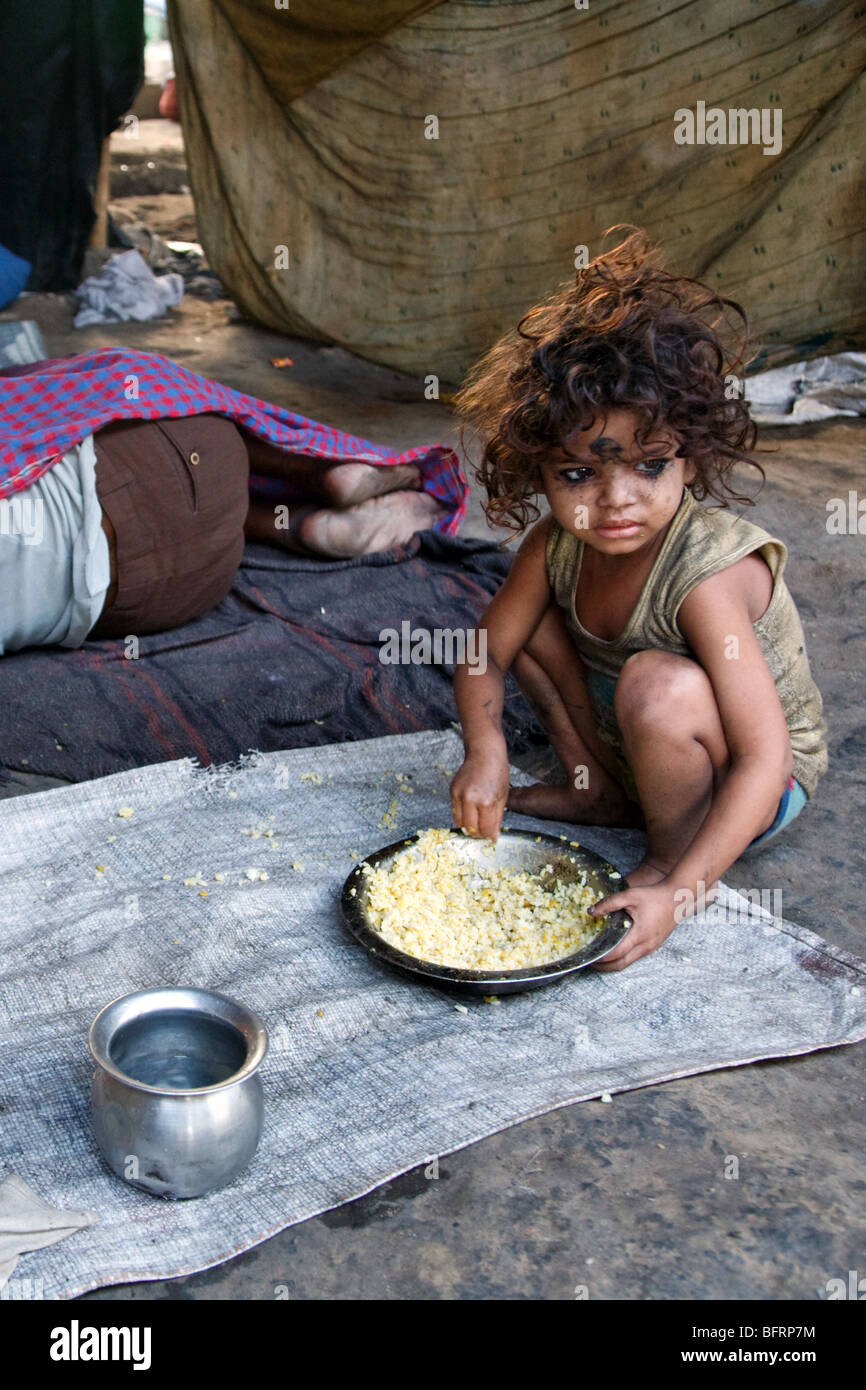 A little homeless girl having her breakfast under one of the bridges in Kolkata, India Stock Photo