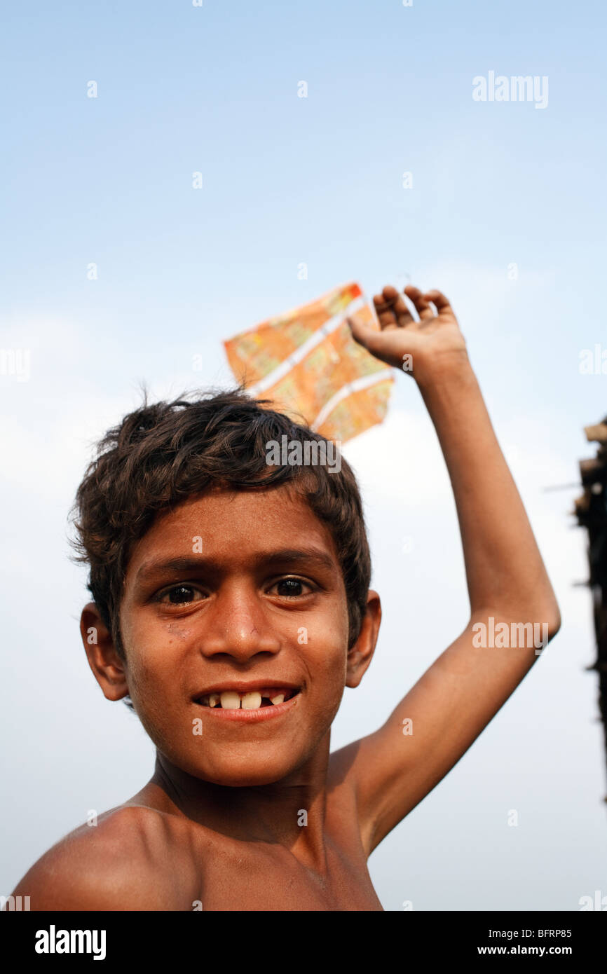 a portrait of a smiling boy with a kite in one of the slums in Kolkata, India Stock Photo