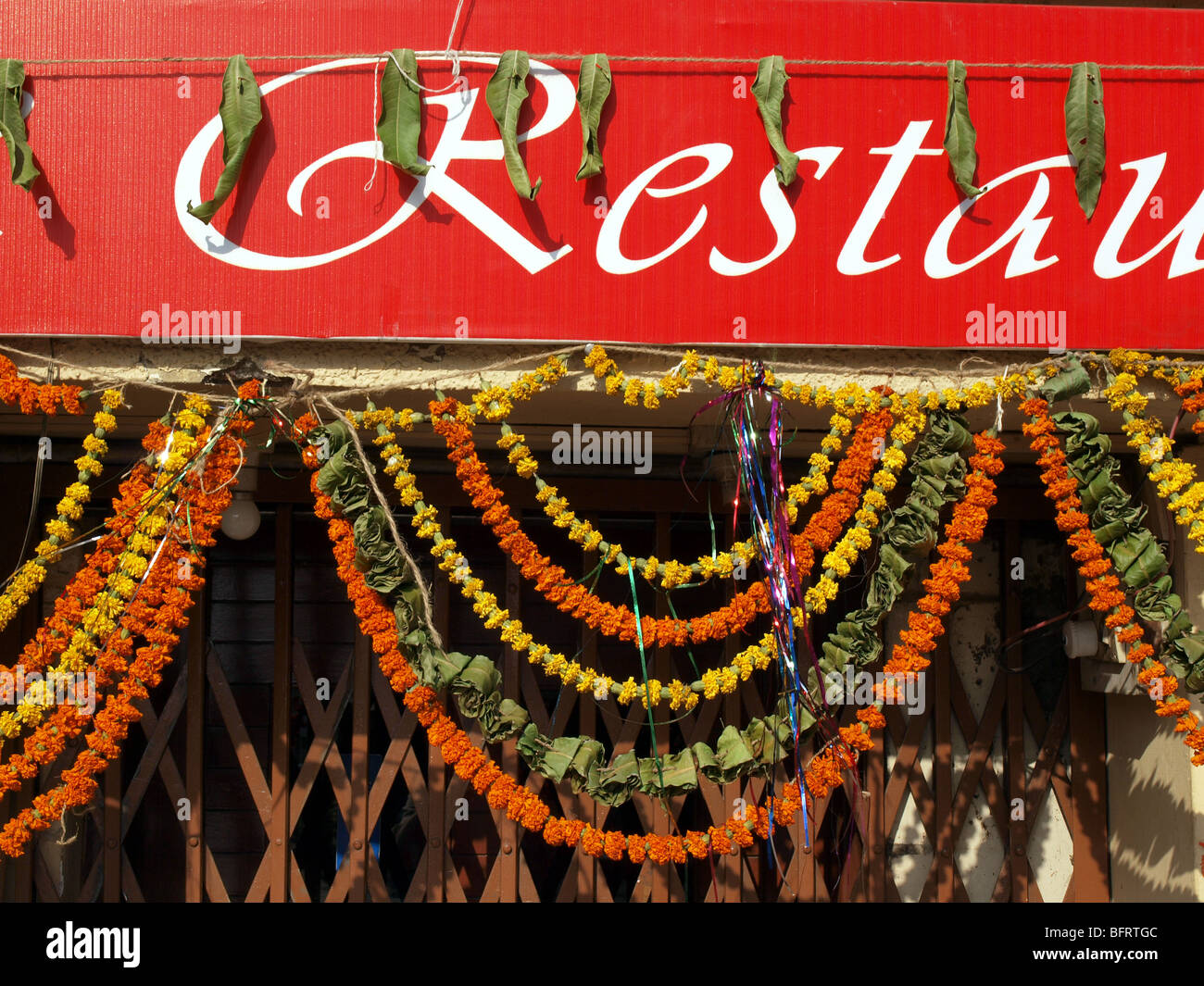 Red fascia of restaurant in Nagpur India festooned with garlands of