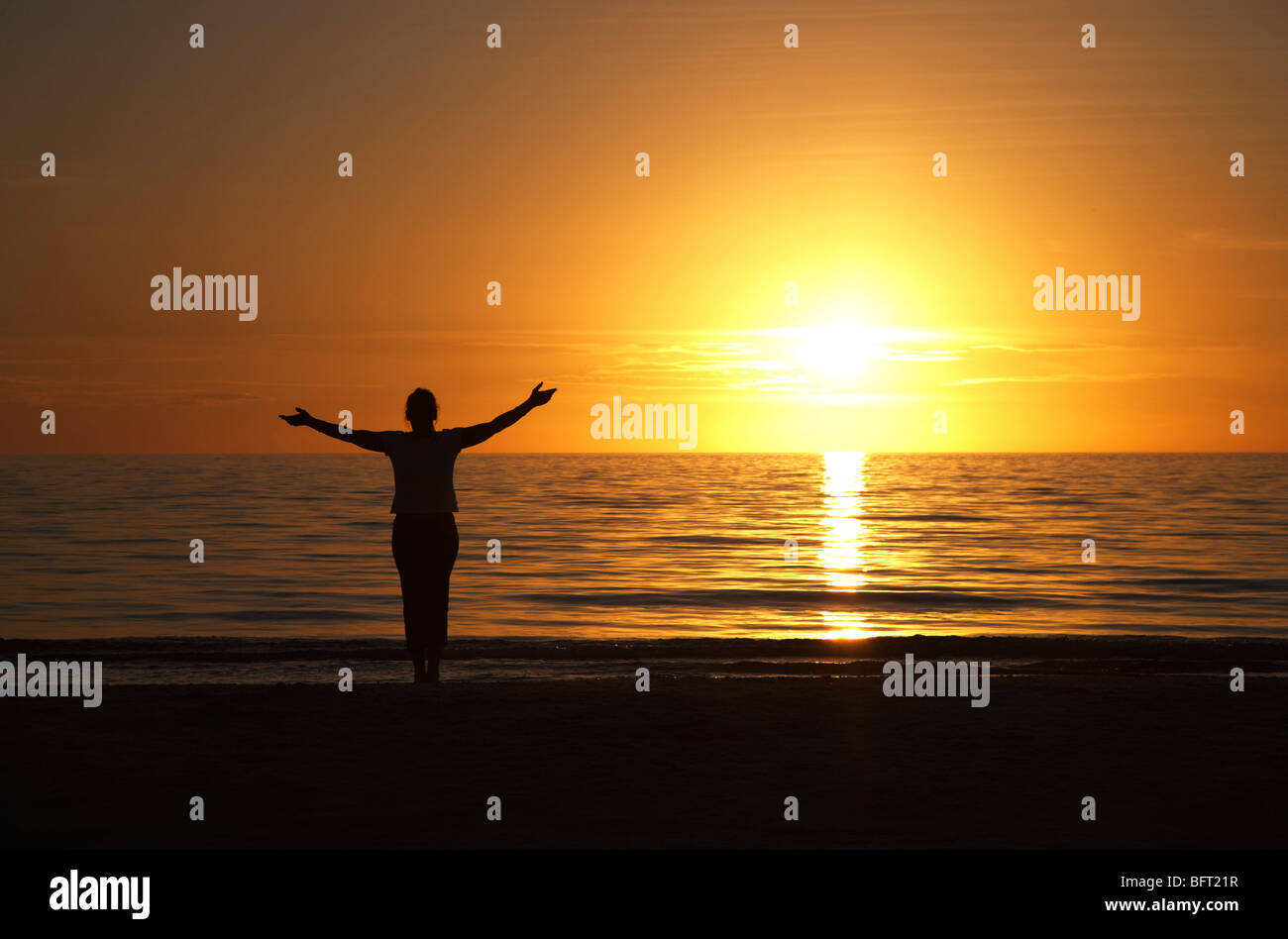 One woman arms open sunset sea hi-res stock photography and images - Alamy
