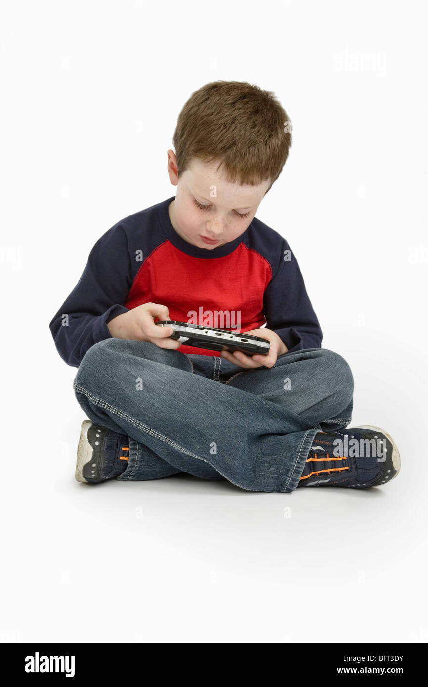 Boy Playing Handheld Video Game Stock Photo