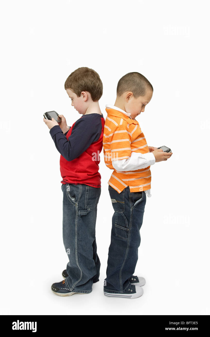 Boys with Handheld Video Games Standing Back to Back Stock Photo