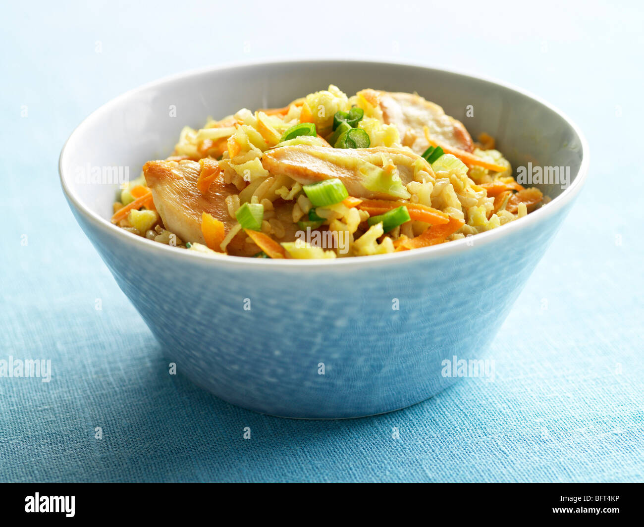Fried Rice with Chicken, Green Onions and Orange Peppers in Bowl Stock Photo