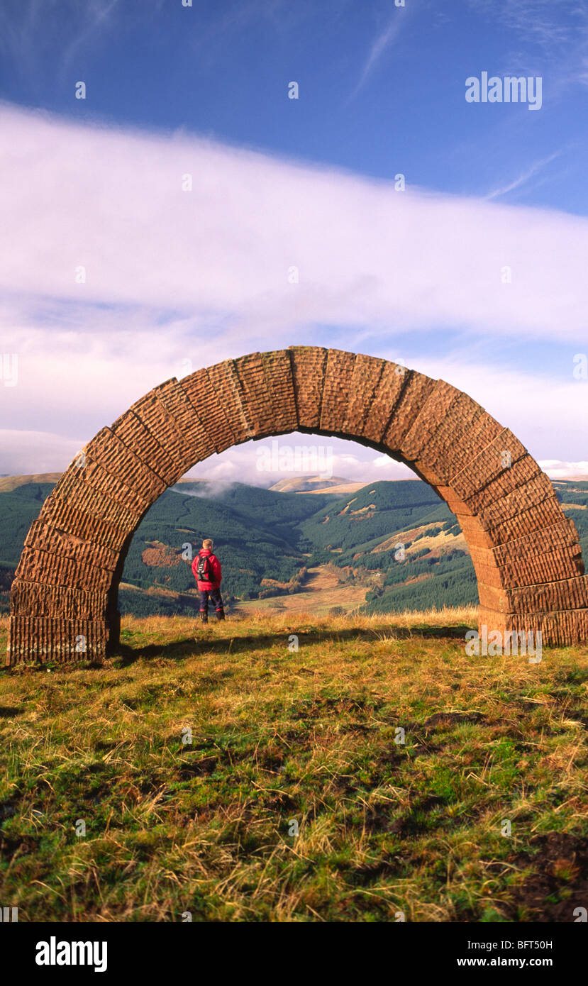 Andy Goldsworthy enviromental sculpture Striding Arches on Bail Hill with walker admiring the view up to Glenhead near Moniaive Stock Photo