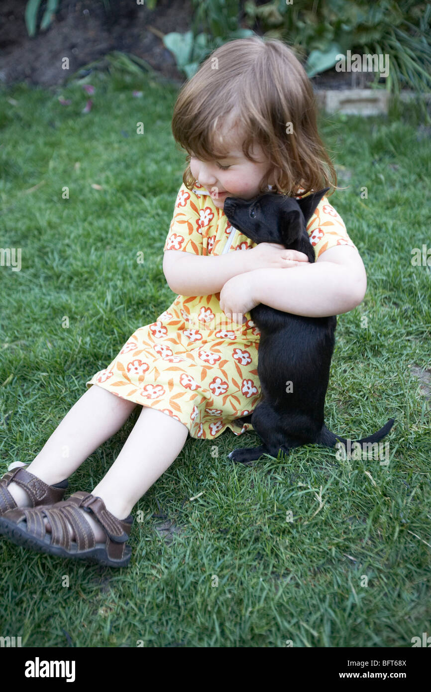 Little Girl Playing With a Puppy Stock Photo