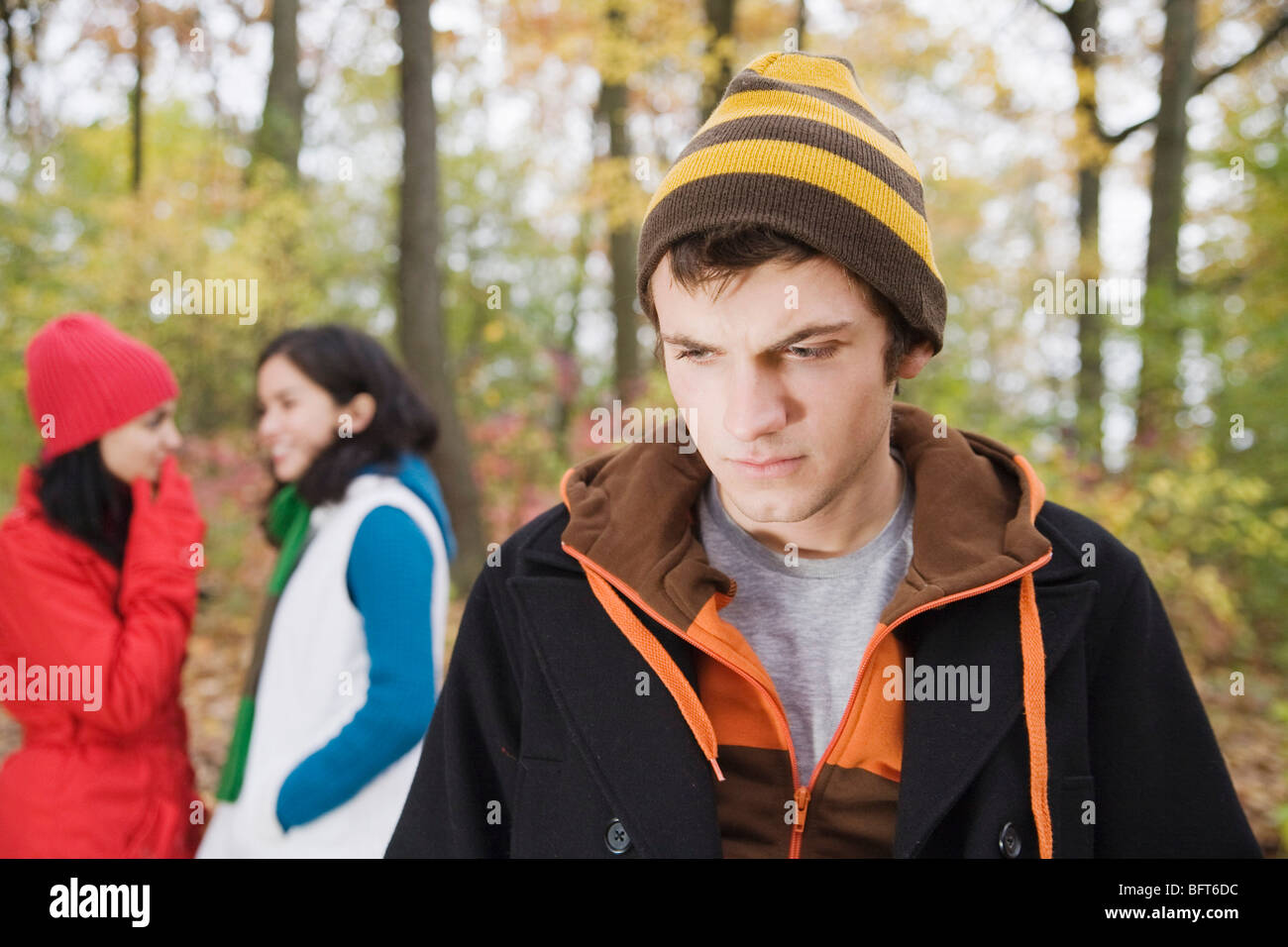 Women Talking behind Man's Back Stock Photo