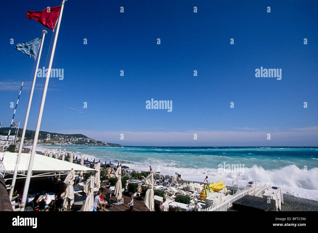 Rough sea and red flag on the beach of Nice Stock Photo