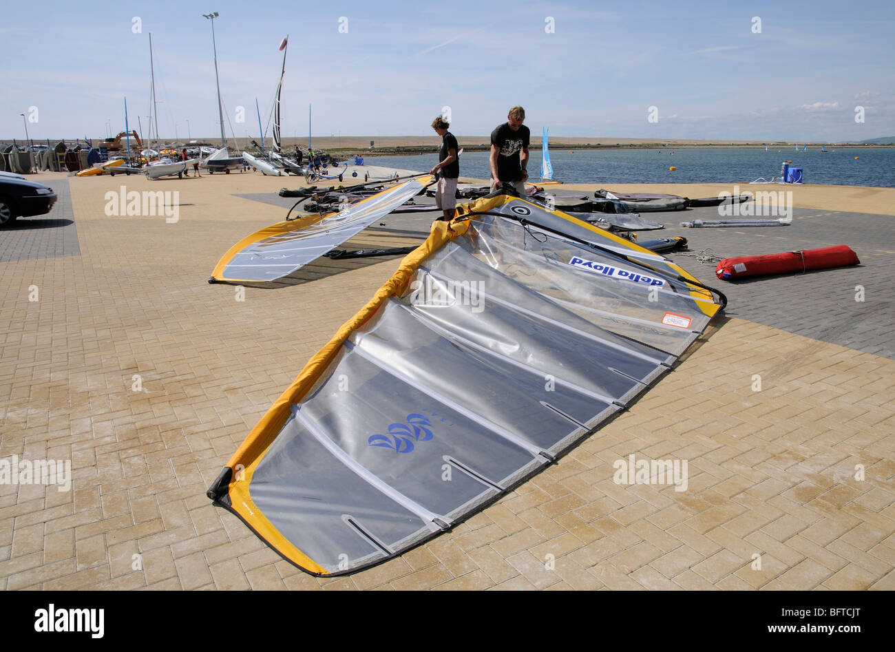 Weymouth & Portland National Sailing Academy waterfront windsurfers prepare their boards before taking to the water Stock Photo