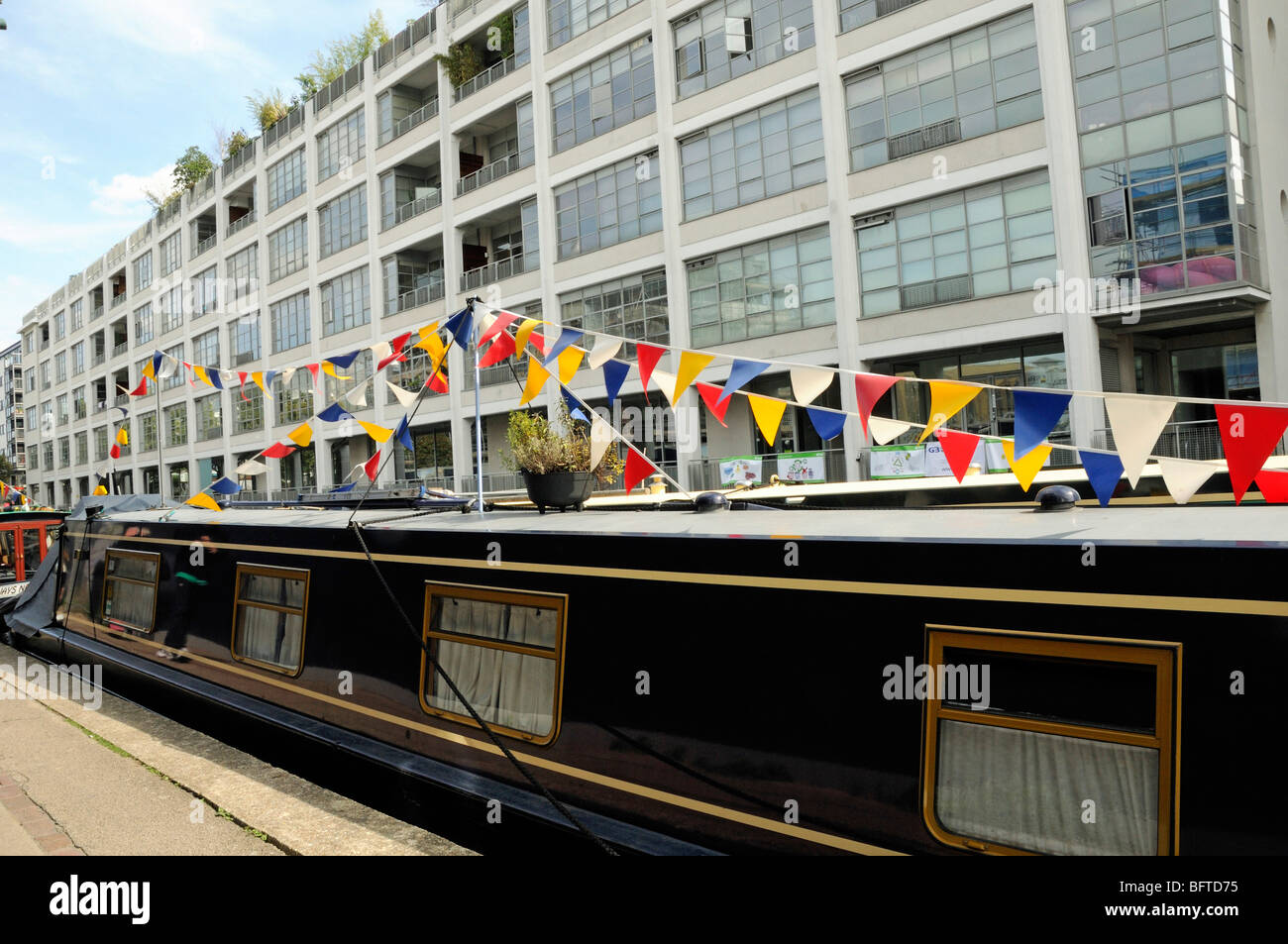 Canal Boat decorated with bunting Regent's Canal with flats behind