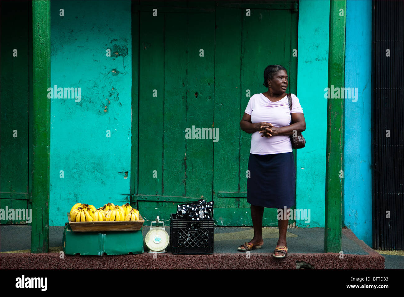 Black woman selling bananas from a basket in the street, St Johns