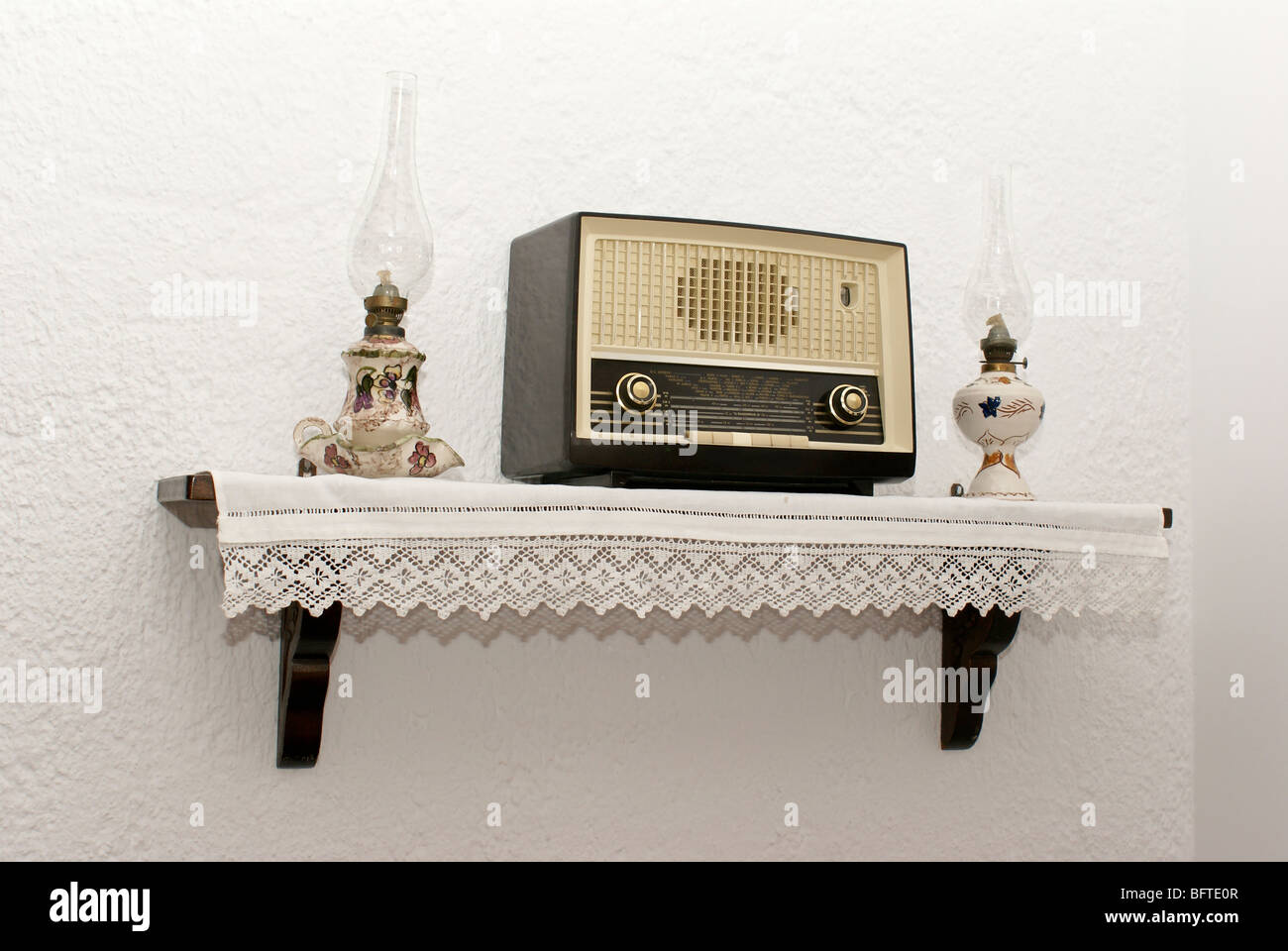 Antique radio on the wall with two old traditional lamps Stock Photo