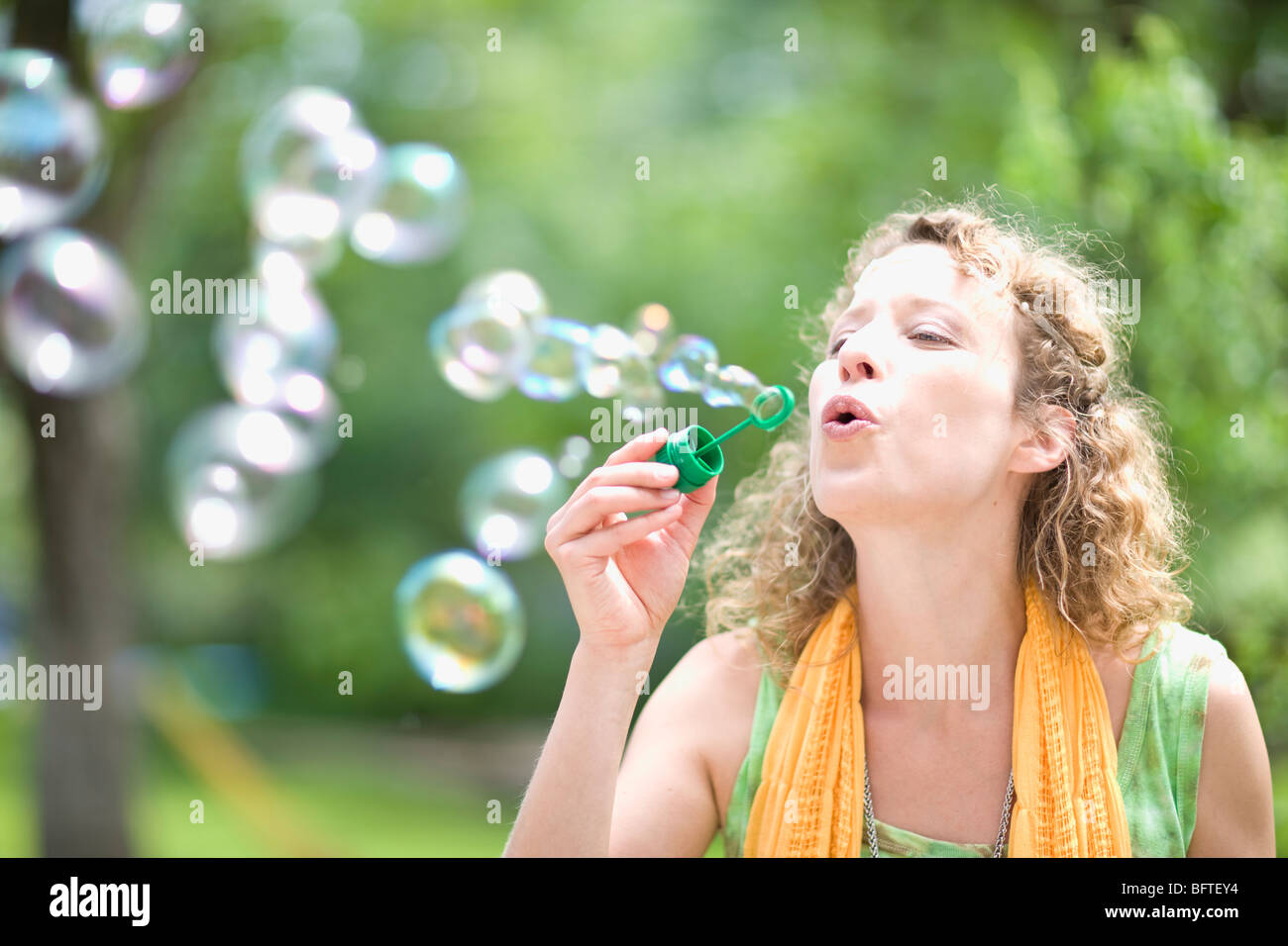 young woman blowing bubbles Stock Photo