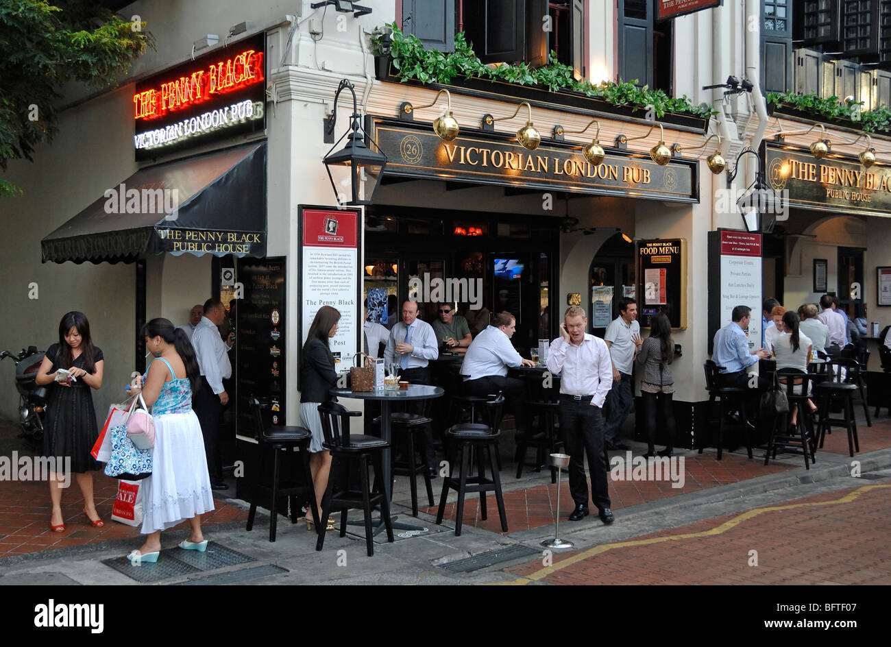 Office Workers Drinking in the Penny Black, Victorian London Pub, an English or British Theme Bar, on Boat Quay, Singapore Stock Photo