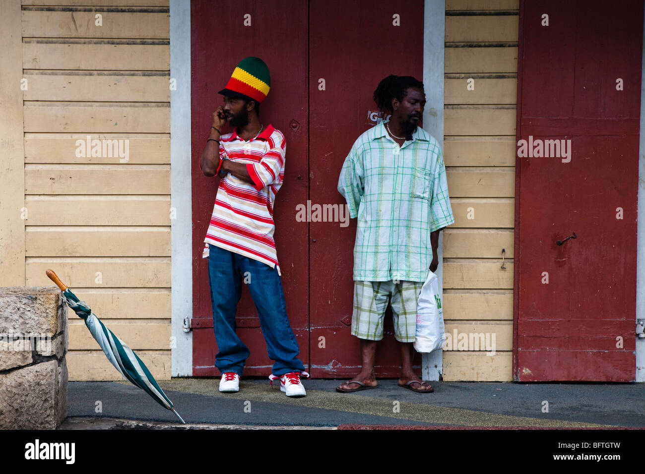 Two men standing at a street corner, St Johns, Antigua Stock Photo