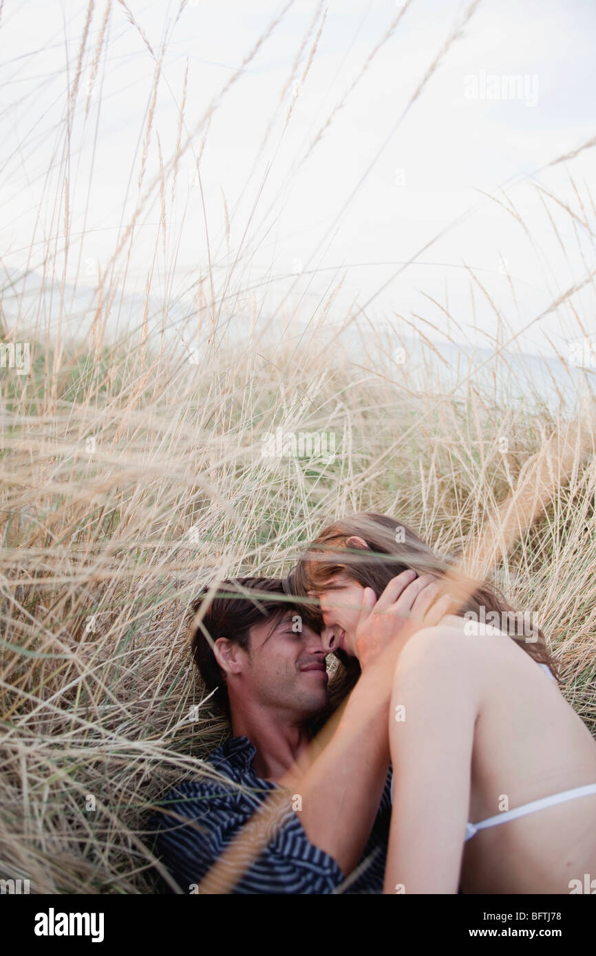 couple lying in reed embracing Stock Photo