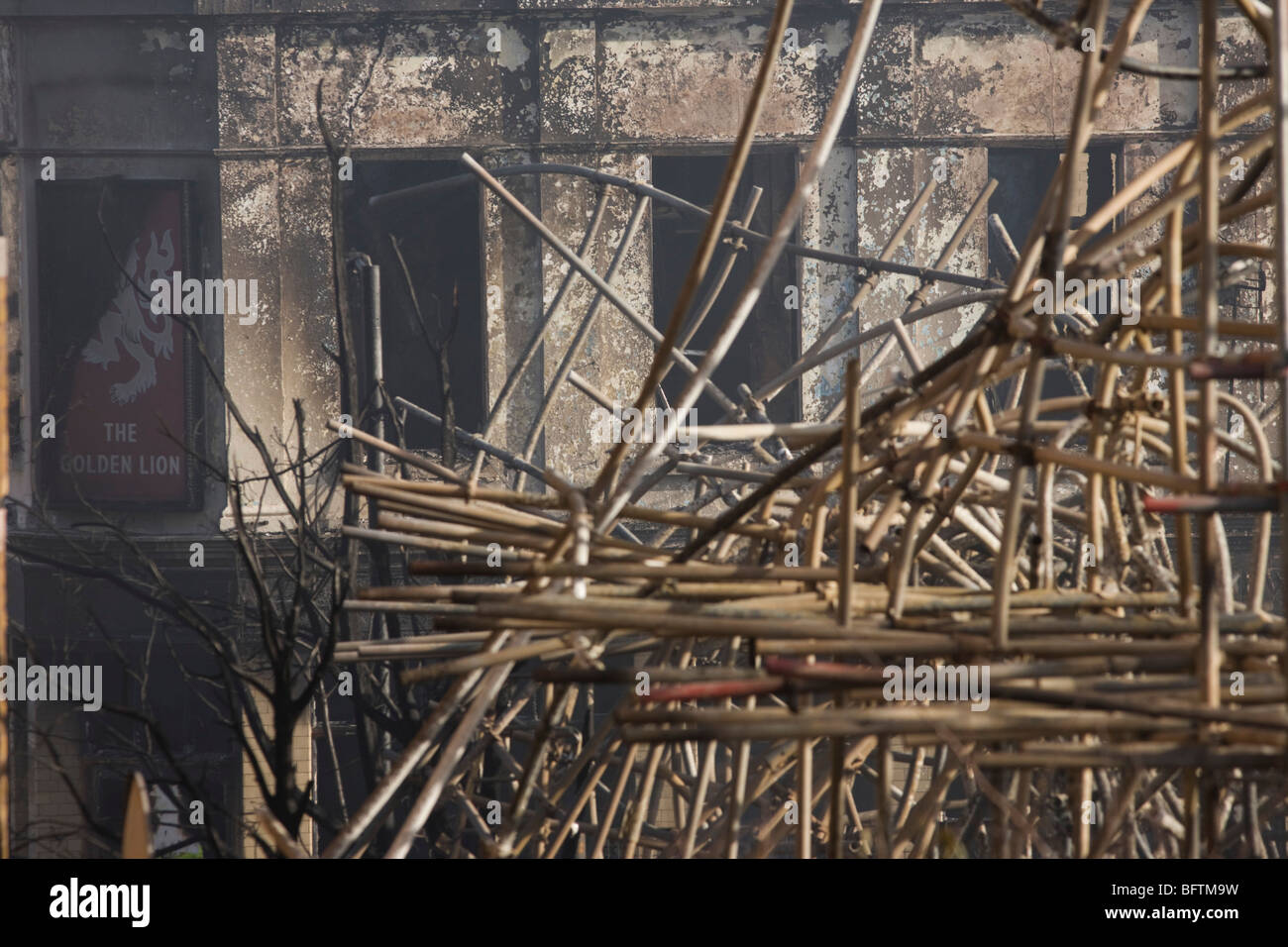 The charred remains of the Golden Lion pub amid twisted scaffolding after an inner-city estate fire in south London. Stock Photo