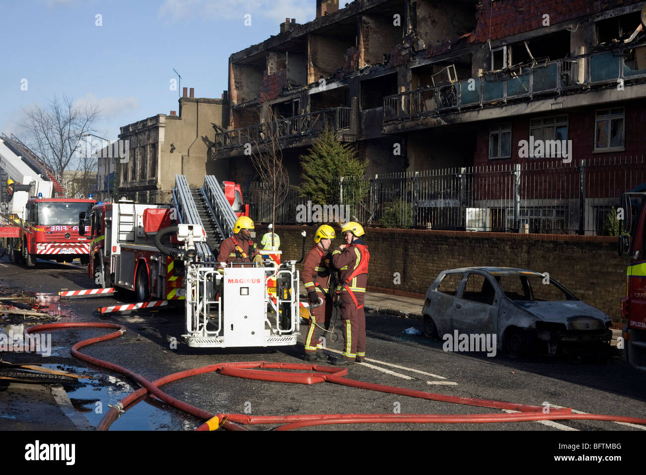 Fire fighters in the aftermath of an inner-city estate fire in south London. Stock Photo