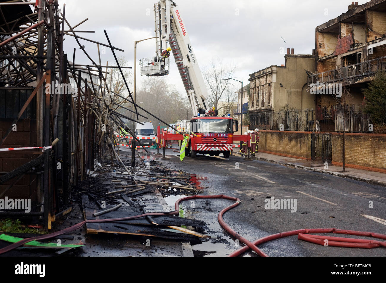 Fire fighters in the aftermath of an inner-city estate fire in south London. Stock Photo