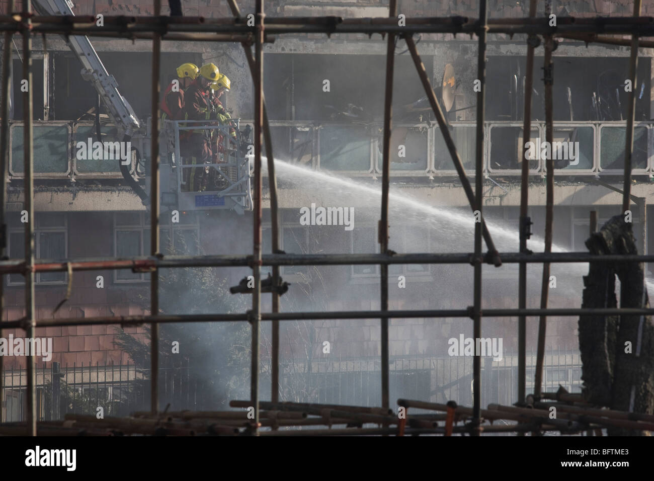 London Fire fighters dampen down smouldering remains from a Simon Snorkel platform after an