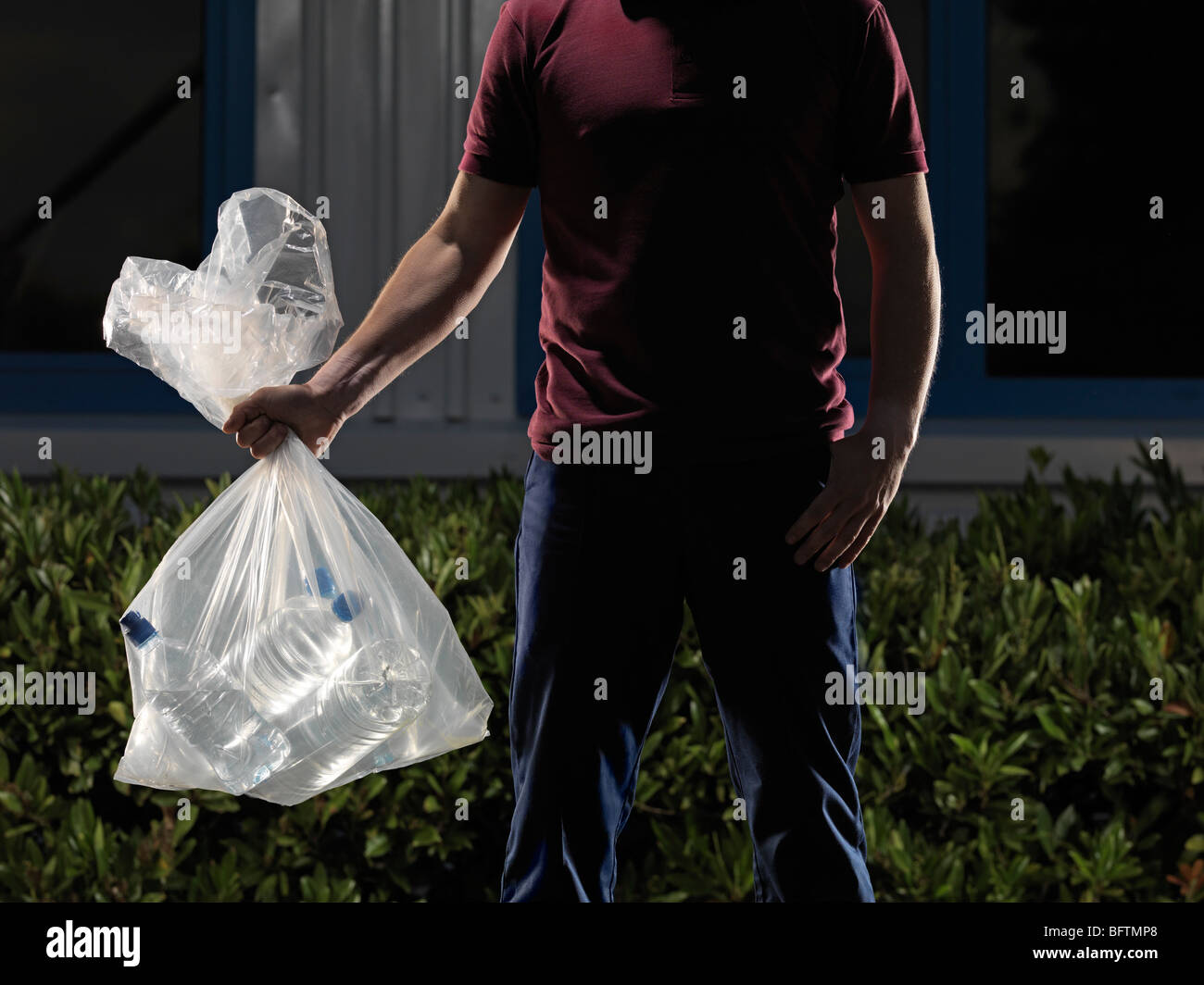 man carrying bag of water bottles Stock Photo