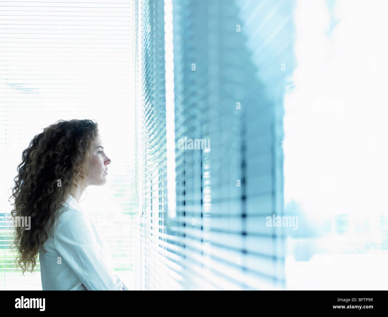 Business woman looking through window Stock Photo
