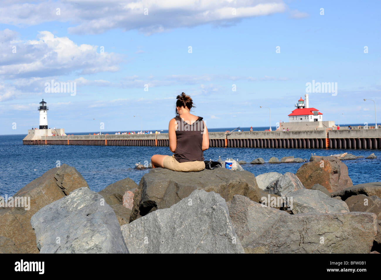 Woman ponders while sitting in harbor area of Duluth Minnesota Stock Photo