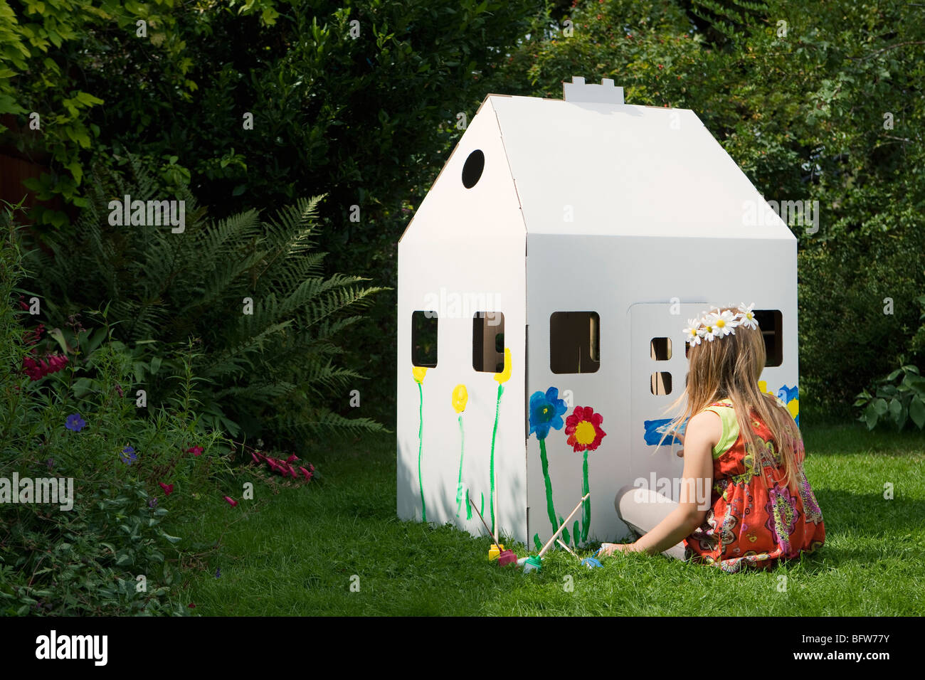 A girl painting a cardboard wendy house Stock Photo Alamy