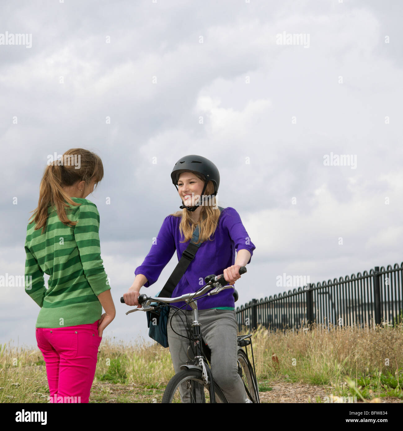 2 young women with bicycle chatting Stock Photo