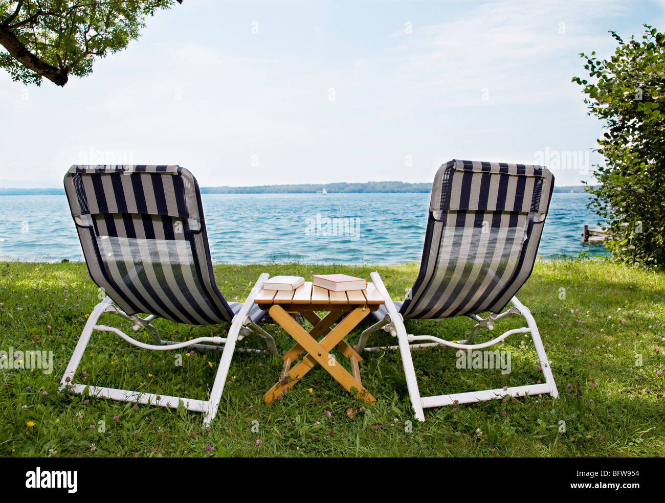 two deck chairs and books at lake Stock Photo - Alamy