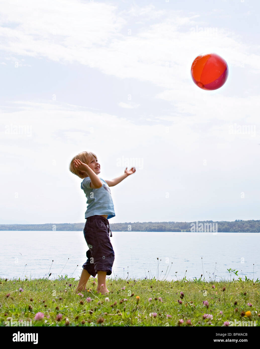 boy playing with ball at lake Stock Photo - Alamy