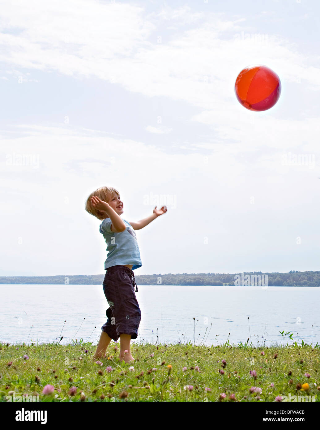 boy playing with ball at lake Stock Photo