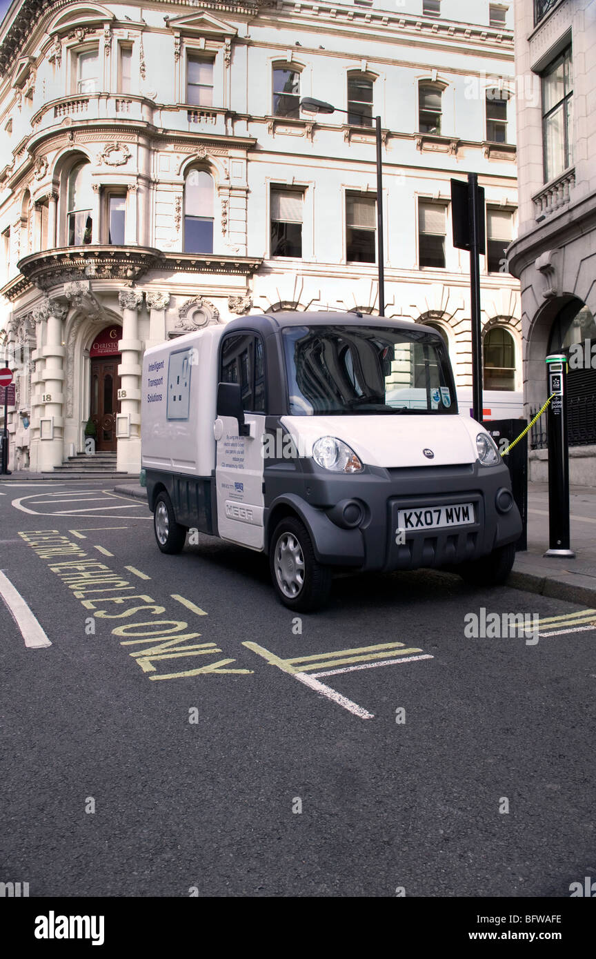 Electric delivery van being charged up at stret power point. London UK Stock Photo