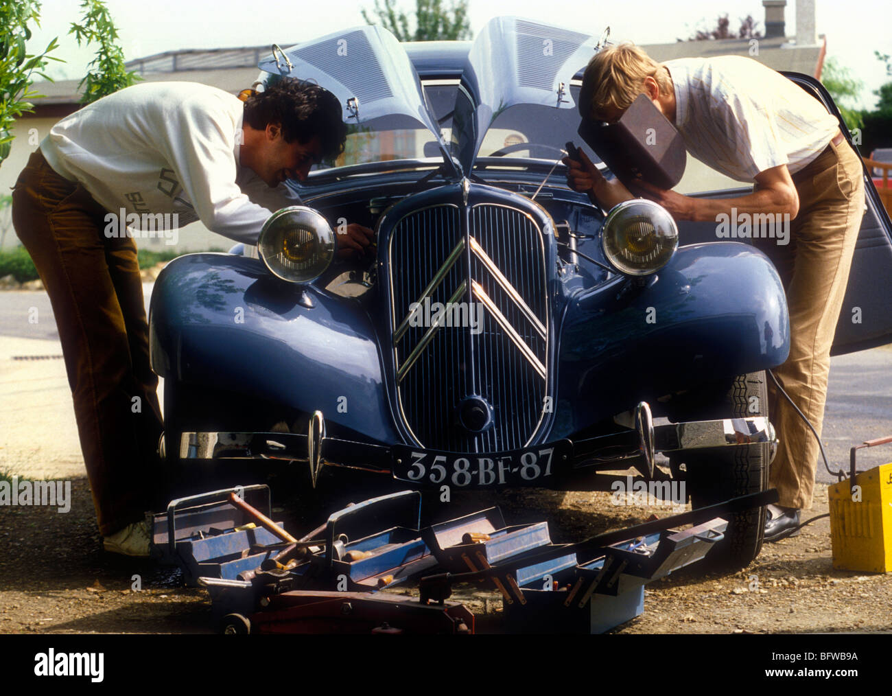 Two enthusiasts working on a 1950's Citroen Traction Avant. Stock Photo