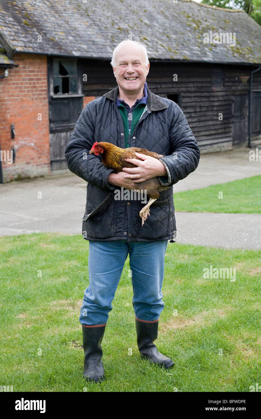Farmer holding chicken Stock Photo Alamy