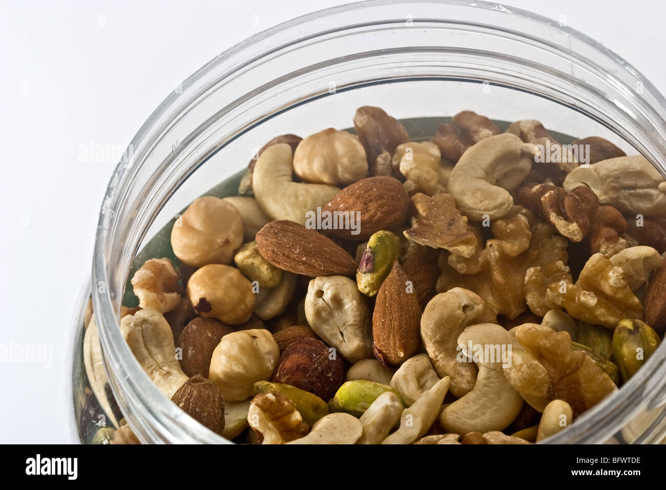 Mixed nuts unsalted in a round plastic jar Stock Photo Alamy